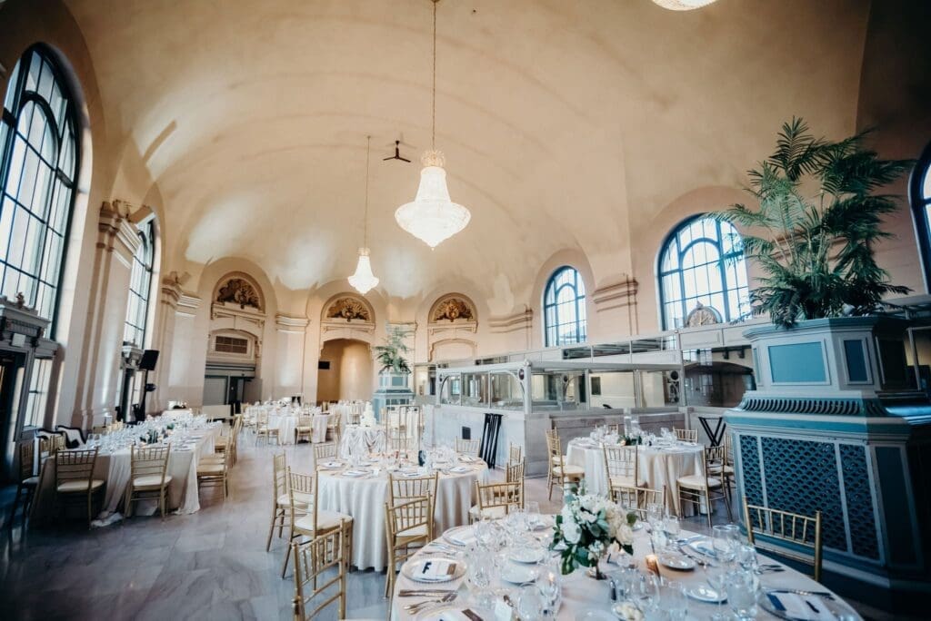 The Grand ballroom at Joliet Union Station set for a wedding with chandeliers and gold chairs.